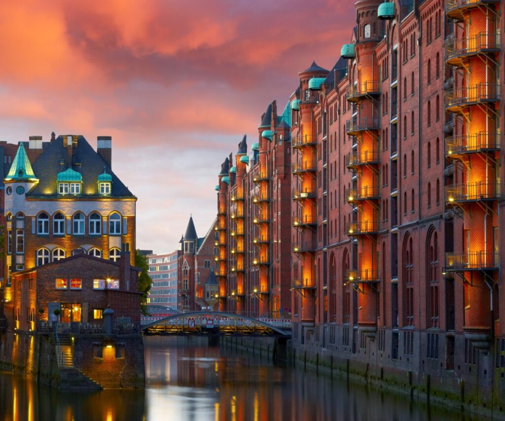 Die alte Speicherstadt in Hamburg, nachts beleuchtet. Sonnenuntergang im Hintergrund
